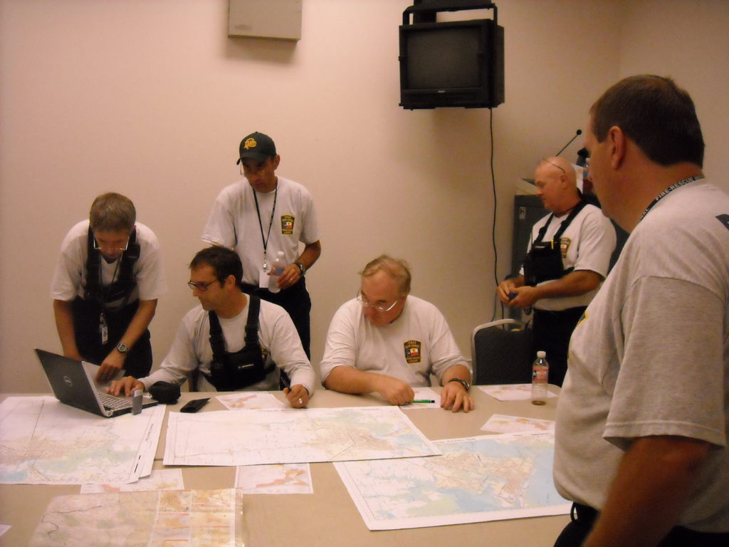 TX-TF2 members gathered around a table looking at maps of the area and planning their operations for the day